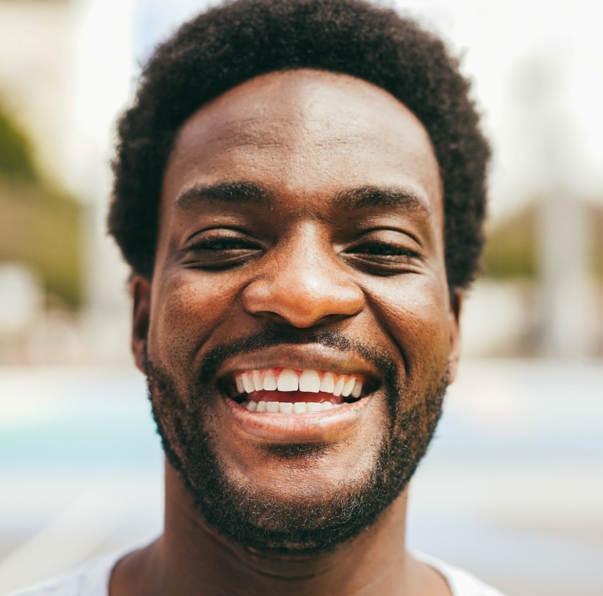 Testimonials happy african man smiling at camera inside ba 1.jpg